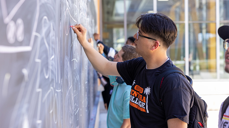 Image of a student writing on Applied Science Chalk Wall